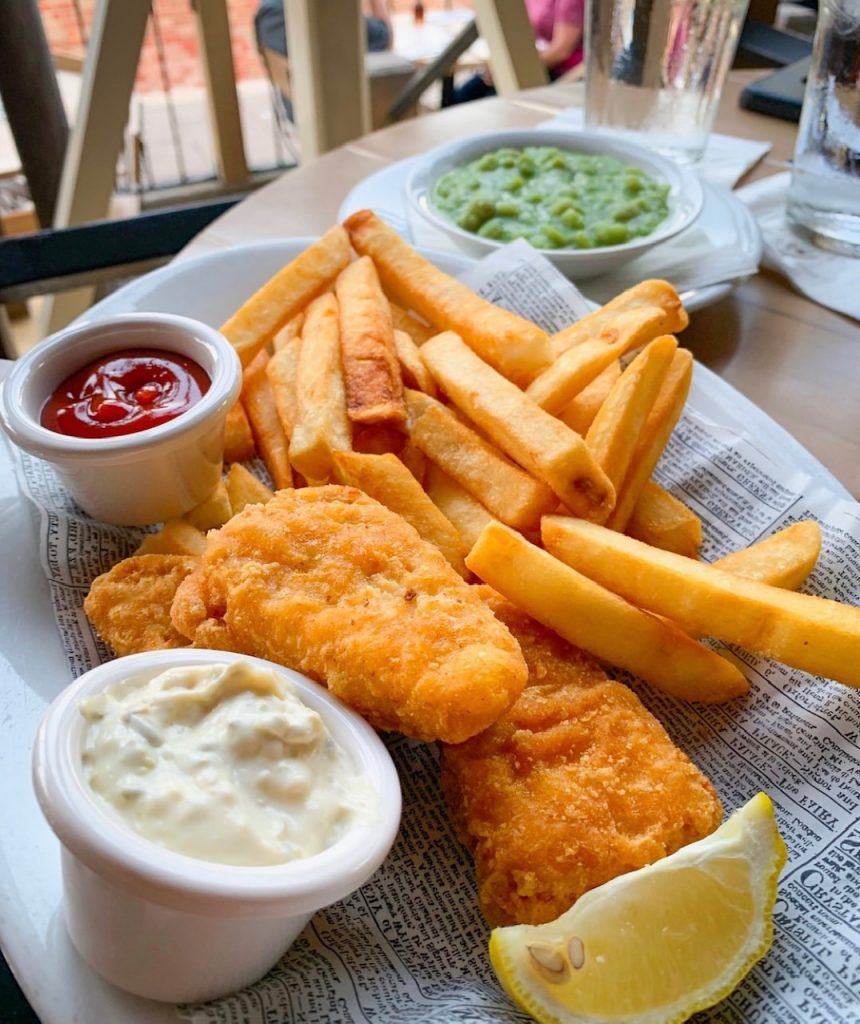 plate of fish and chips with mushy peas and ketchup, some of the best food at Epcot