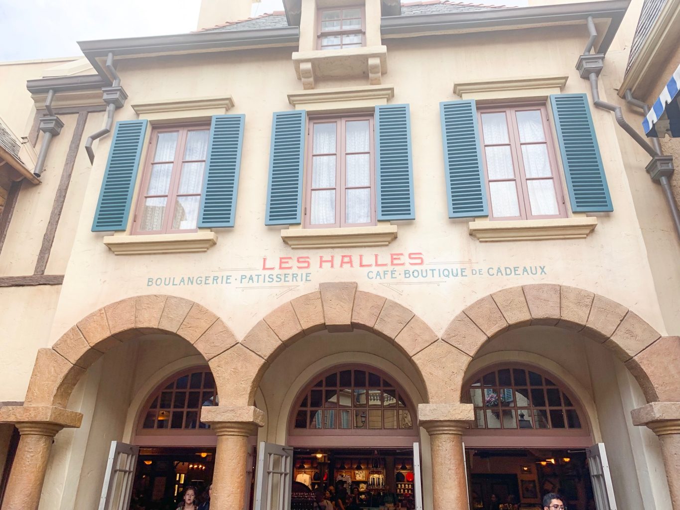 blue shuttered windows on building of Les Halles Boulangerie Patisserie Epcot quick service in France 