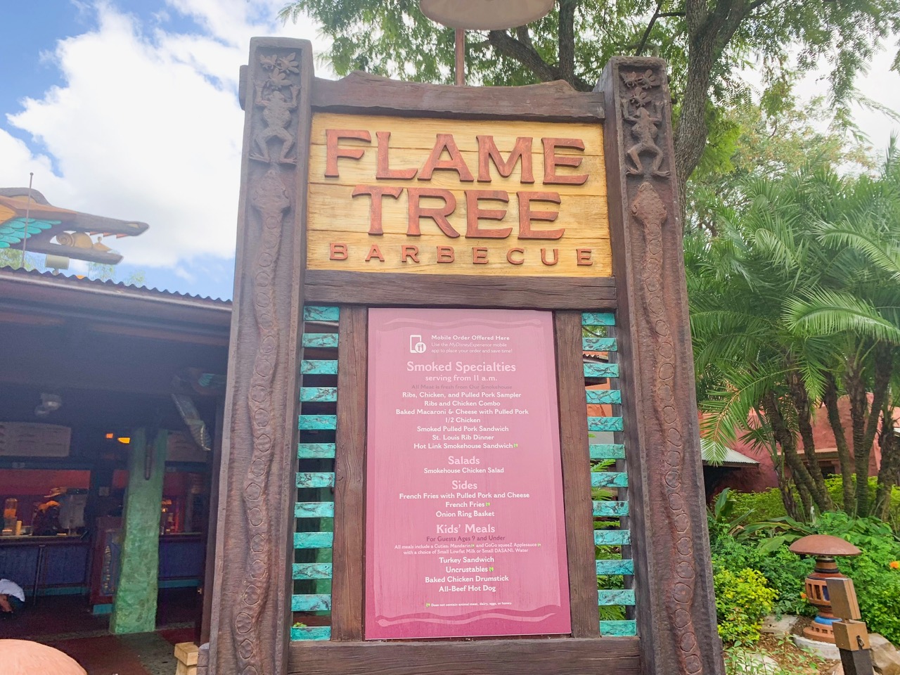 Flame Tree Barbecue Sign and menu in front of trees Animal Kingdom quick service