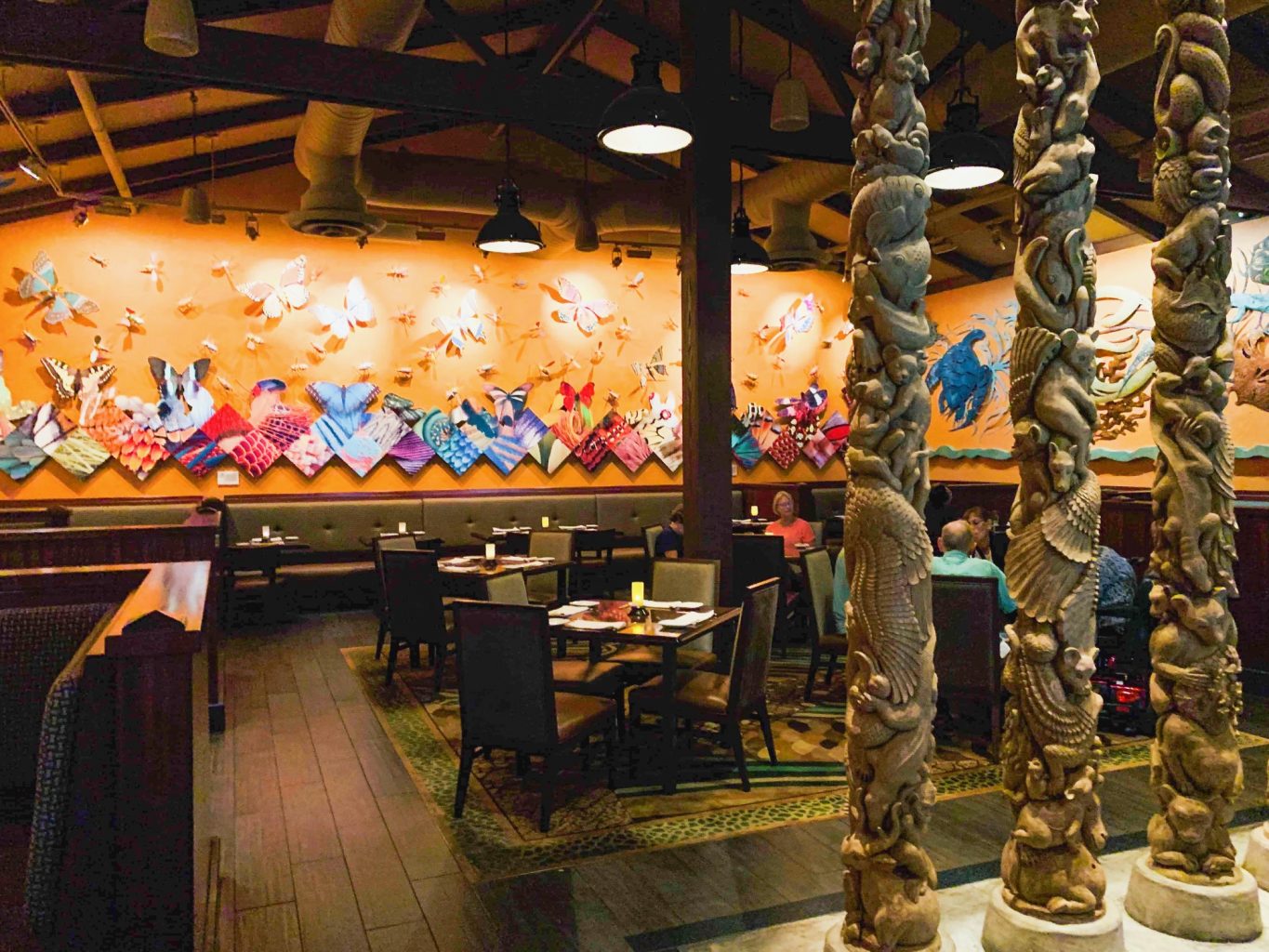 The elaborate animal totem poles in front of brightly colored background is only one sneak peak of the inside of one of the best Magic Kingdom restaurants. 