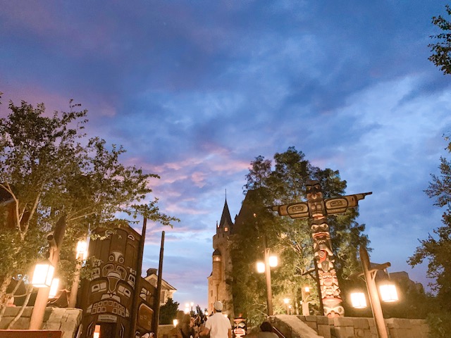 Countries in Epcot Canada view of the totem poles at sunset with a blue and red sky