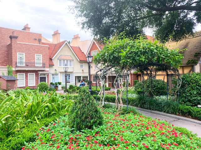 Countries in Epcot view of United Kingdom Pavilion with green gardens, trees, and front of shops