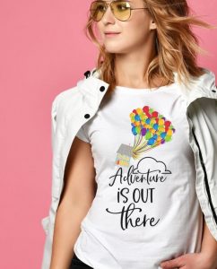 girl in front of pink background wearing Disney's Up-inspired shirt