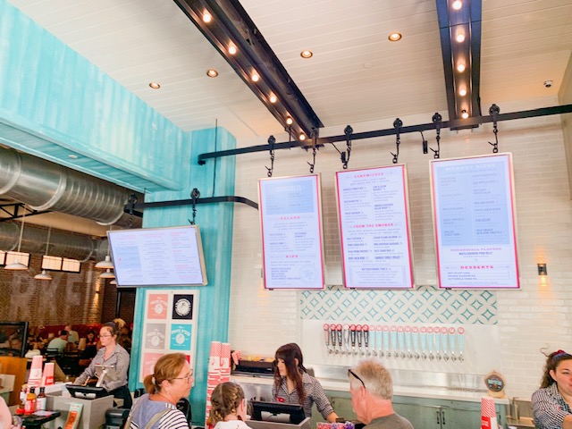 Disney Springs Restaurants bakery interior hanging menu of three boards above bakery counter