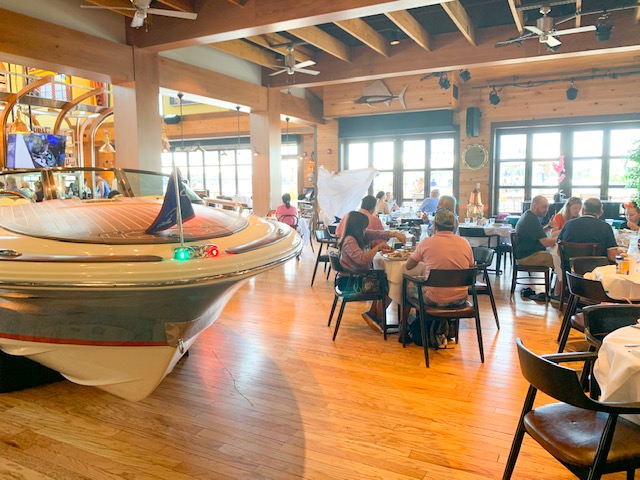 Disney Springs Restaurant the Boathouse interior dining room include boat and people at tables