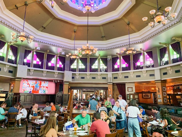 Disney Springs Restaurants Raglan Road interior main dining room with stained glass and chandeliers with people at tables
