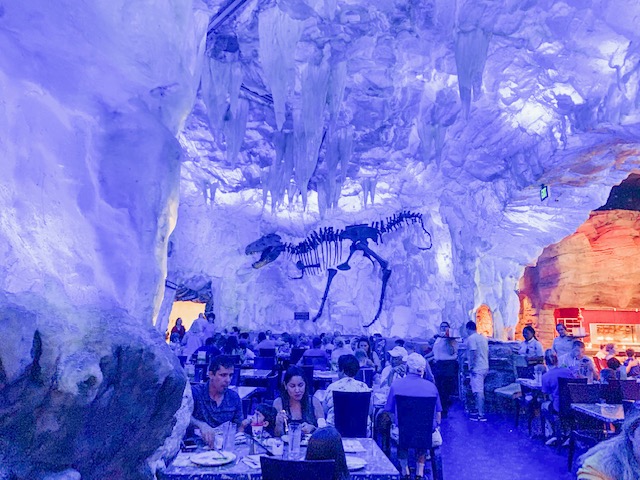 dining room with icy rock sculptures and a t-rex skeleton painting 