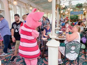 Piglet spending time at a table full of guests character dining at Disney