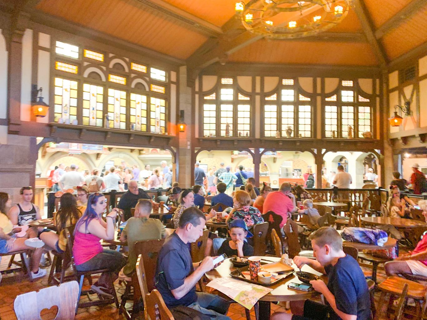 people sitting and eating in large room with wooden decor pinocchio village haus  