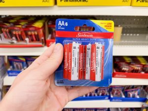 hand holding pack of AA batteries