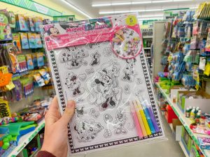 hand holding Minnie-themed Disney coloring poster Dollar Tree Disney