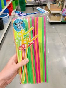 hand holding pack of colorful plastic straws