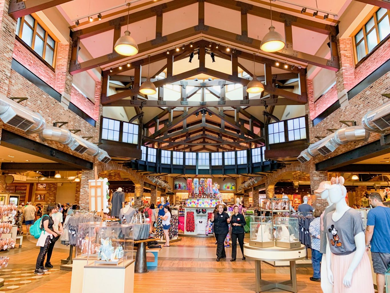 Inside of large Disney Springs Store with a brick interior, lots of windows and open space, with several people walking around shopping