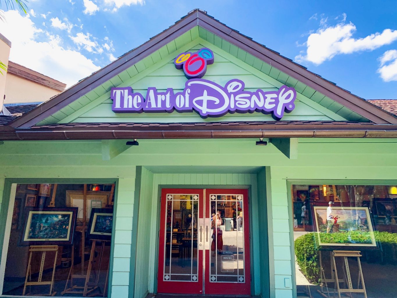 Storefront of Disney Springs Store The Art of Disney which is a green building with white letters outlined in Purple