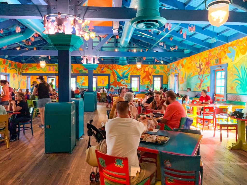 people sitting and eating at bright colored restaurant pizzafari isnt one of the best disney restaurants