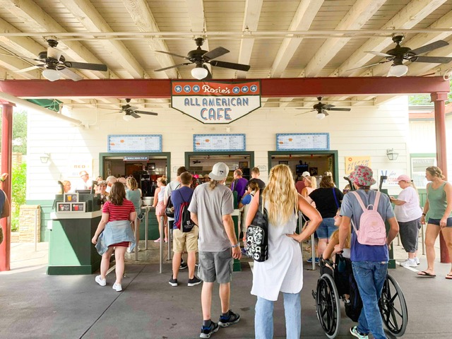 people lined up to order at food window 