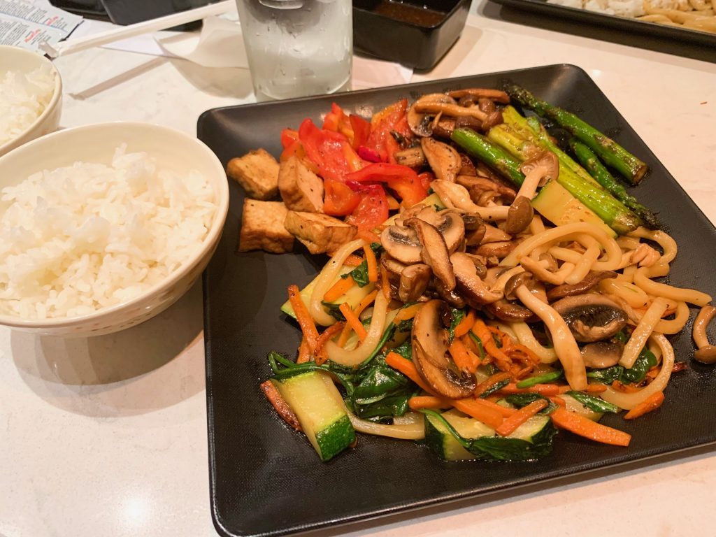 asian vegetables and noodles on a black plate 