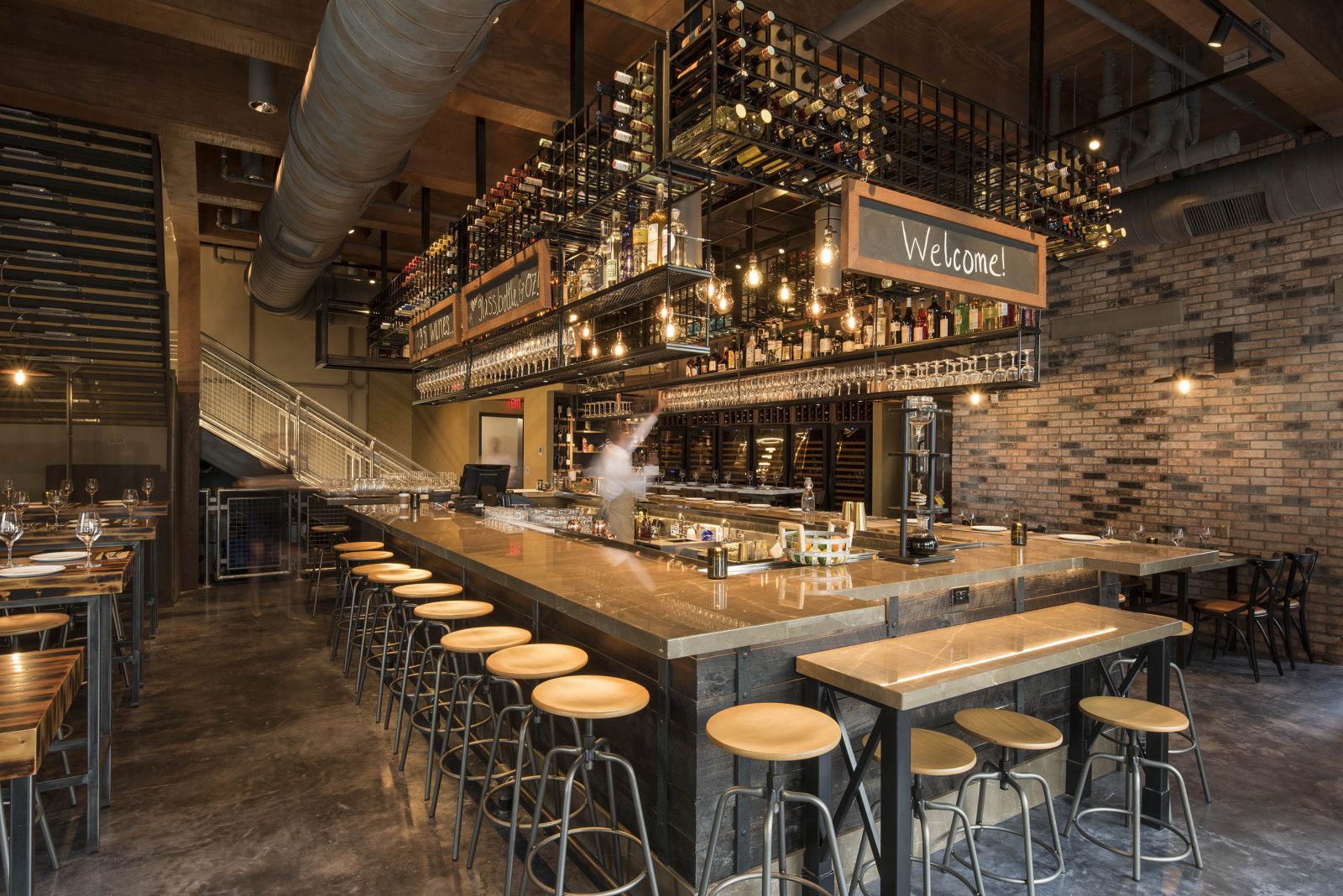 dark wooden bar and stools with wine glasses hanging