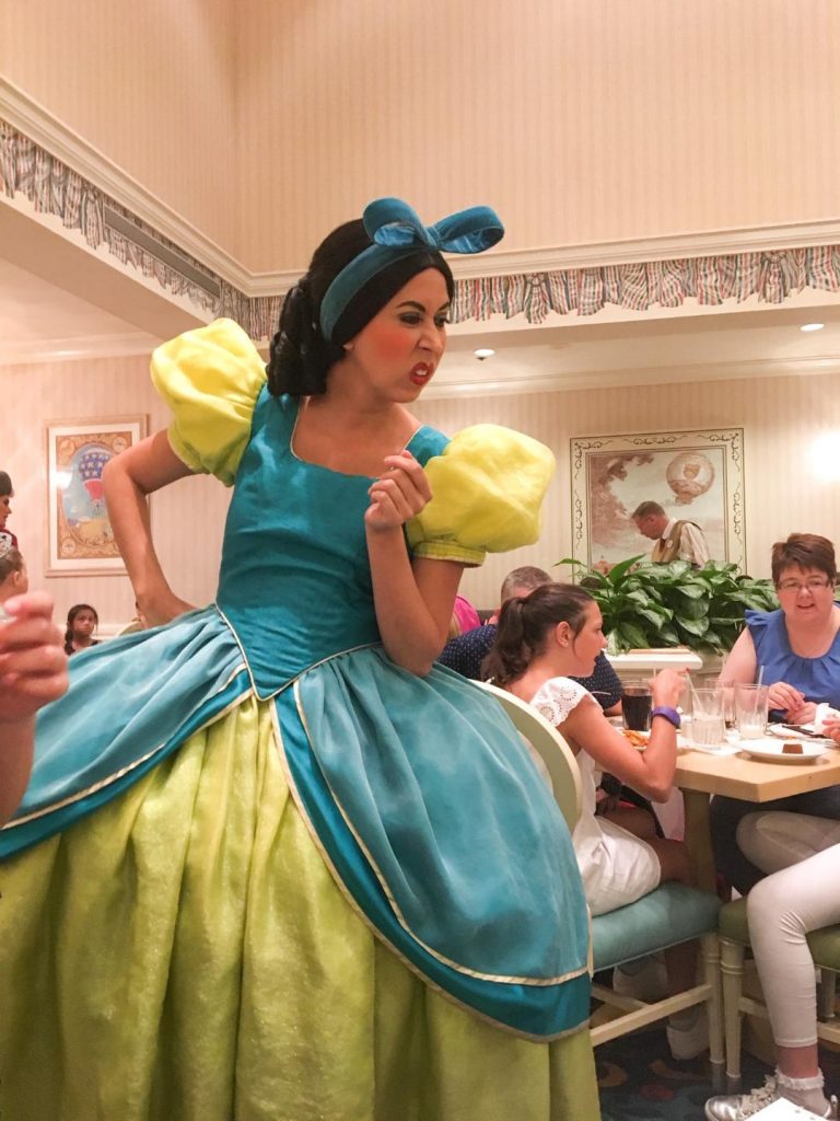 evil stepsister character in blue and green dress at character dining at disney