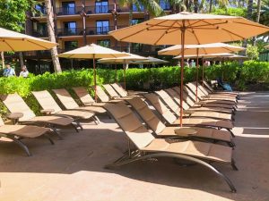 empty pool chairs with umbrellas