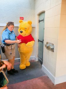 Winnie the Pooh and cast member by secret door