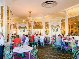 antique white and gold interior with green chairs