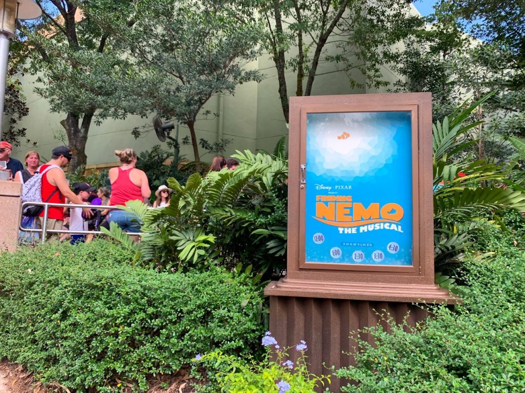 people walking into a theater behind a blue sign best animal kingdom rides