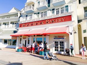 white wooden building with red awning and red name