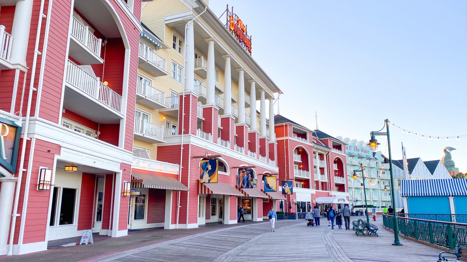 red, yellow, and light blue buildings lining a wooden promenade Disney Boardwalk