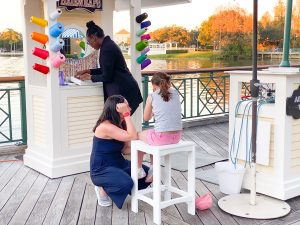 little girl sitting on a white stool getting a hair wrap