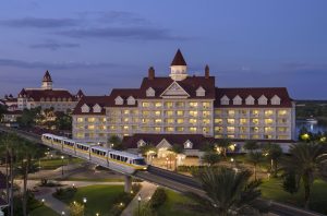 exterior of two large red roof buildings with monorail in front Disney deluxe resorts