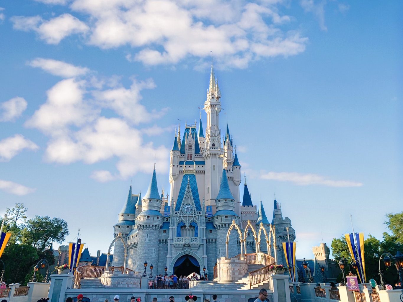 blue and grey castle against a blue sky at the magic kingdom 