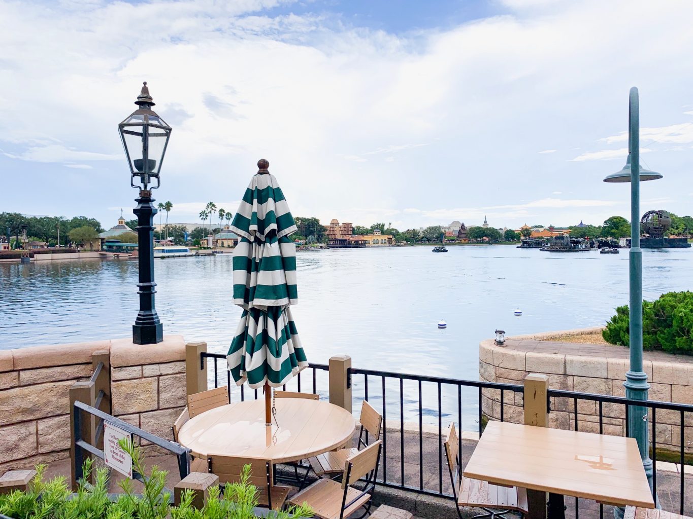 restaurant tables in front of water at world showcase disney on a budget 