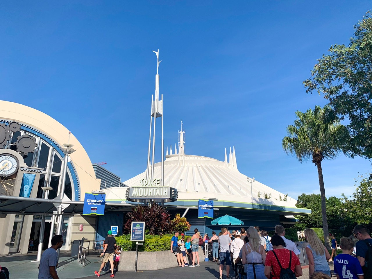 large white space-age building with people lined up in front of it disney on a budget