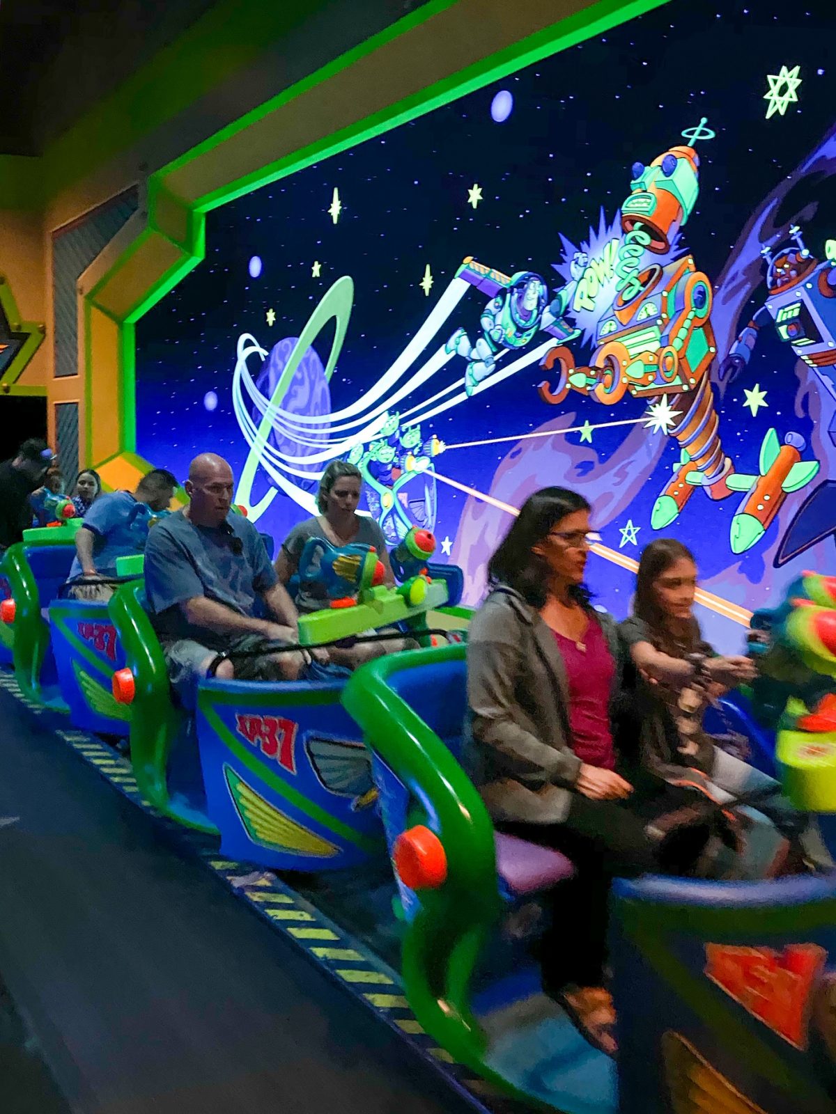 people on Buzz Lightyear ride getting ready to go