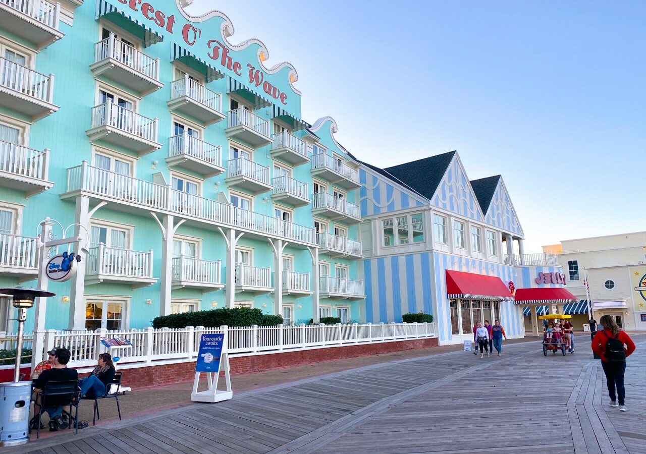 light blue hotel building on boardwalk with red awnings