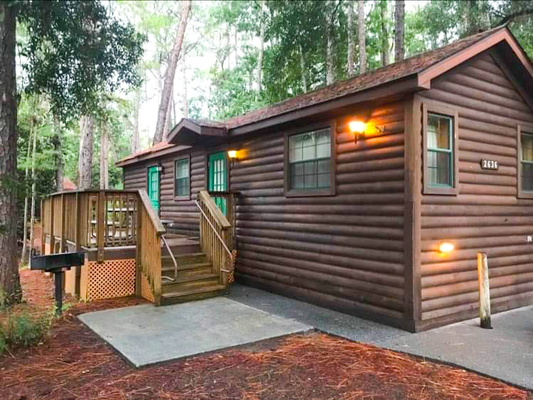 large brown wooden cabin with a porch in the woods best Disney World resorts 