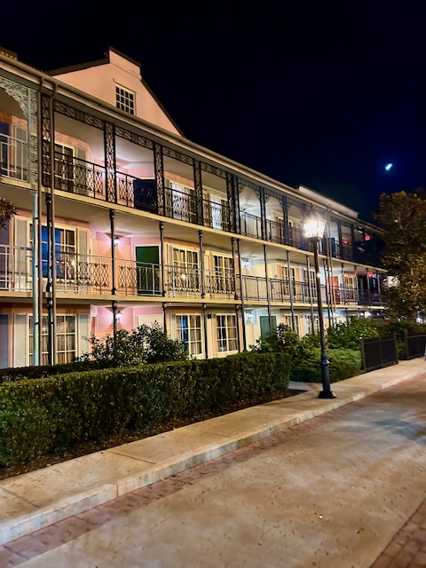colorful hotel building with black iron railings at night with streetlamp best Disney World resorts