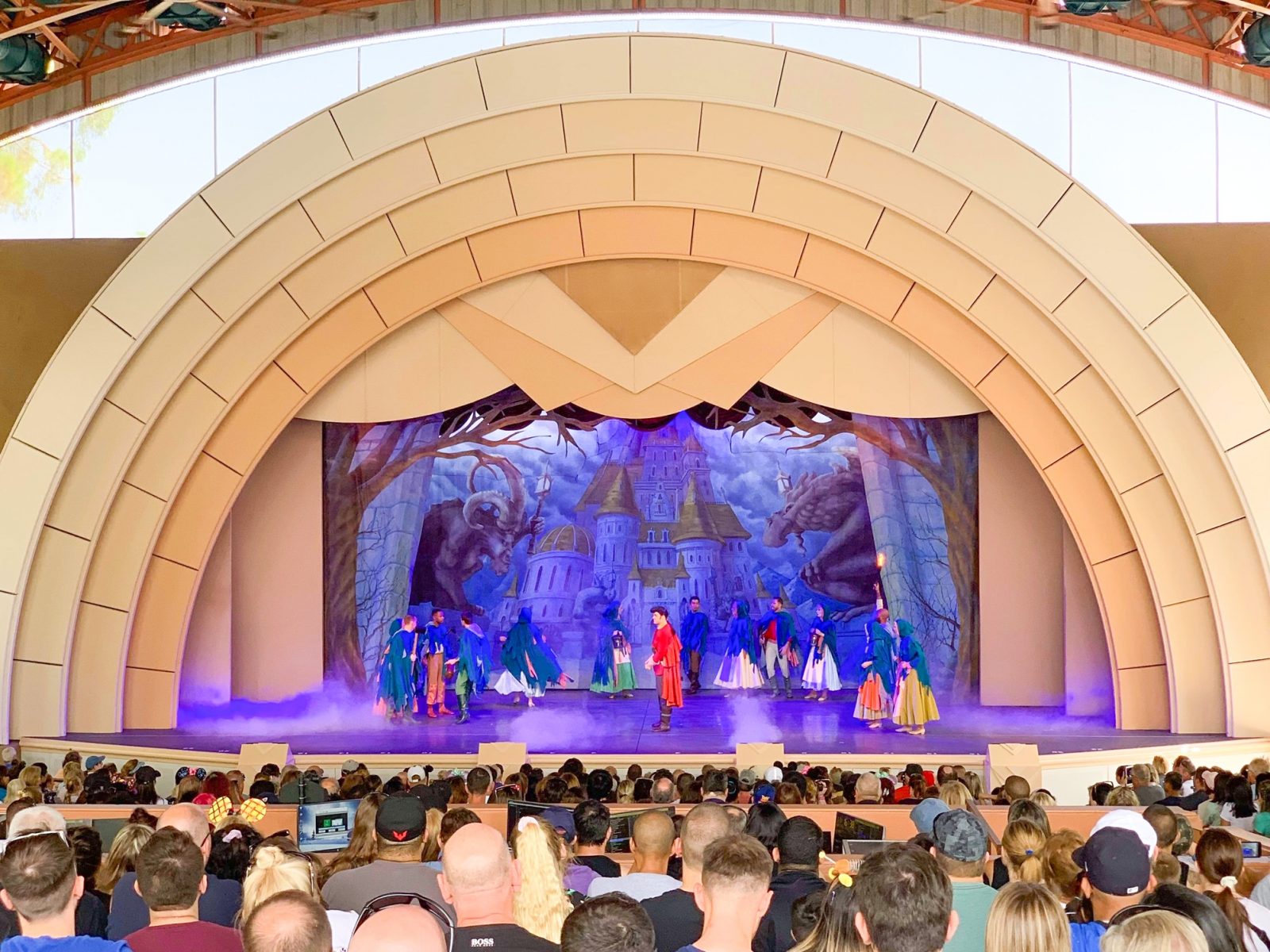 actors on stage while audience watches beauty and the beast best shows at disney world