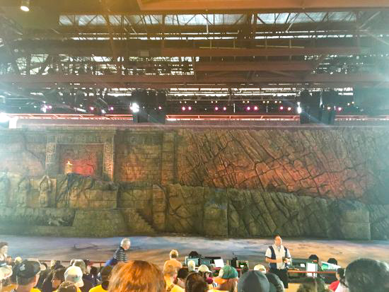 large rock formation and stage with people in audience of Indiana Jones show