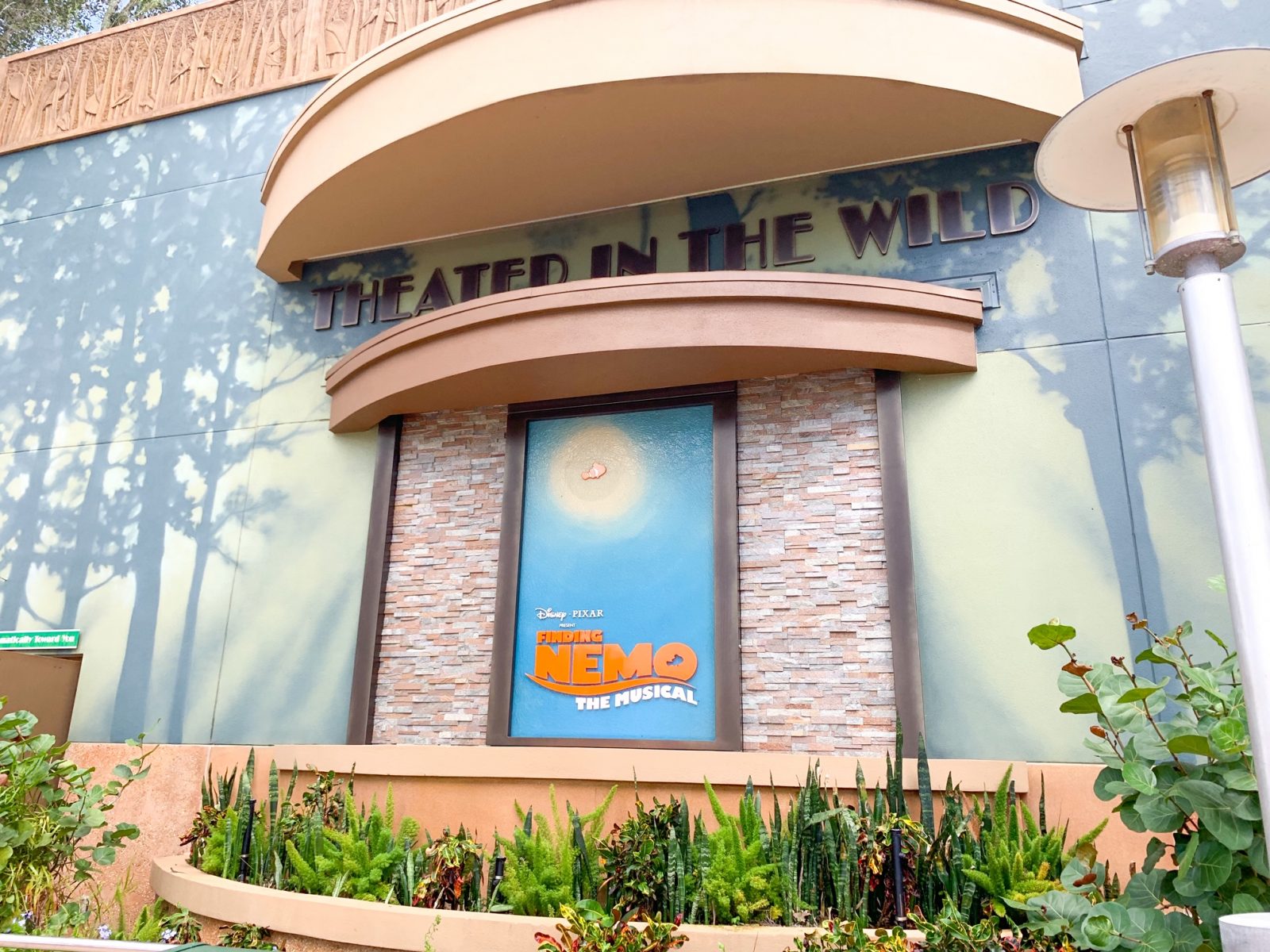 sign for Nemo musical surrounded by bricks and images of trees