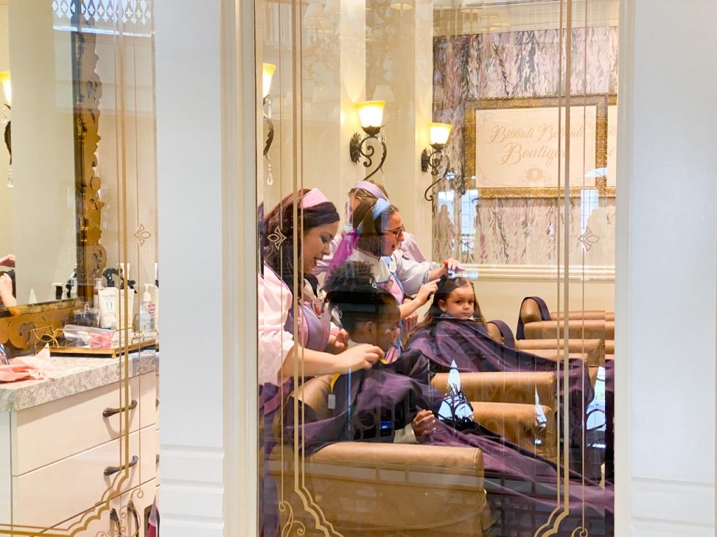 A photo of toddlers having their hair done, princess style; Disney with toddlers can include treating your kids like princes and princesses!