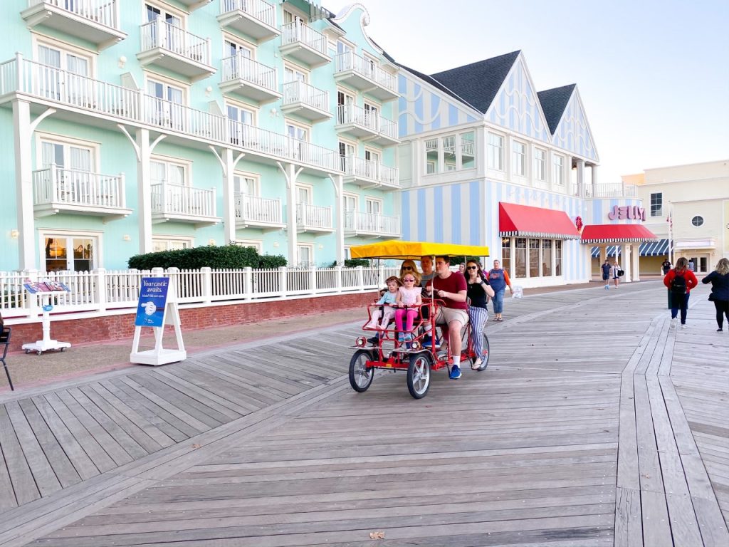 A photo of a family in a Surrey bike on Disney's BoardWalk Inn: renting this bike may be a unique Disney with toddlers experience! 