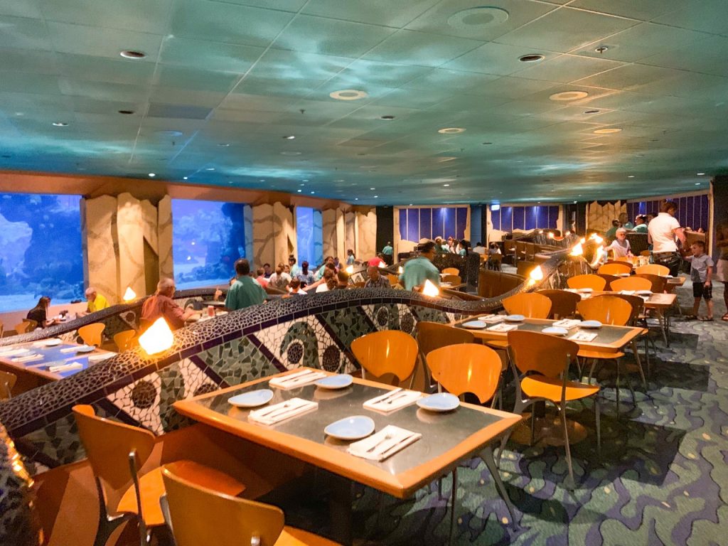 A photo of the inside of the Coral Reef restaurant, at Epcot, where the windows look directly into a huge fish tank, which is perfect for Disney with toddlers!