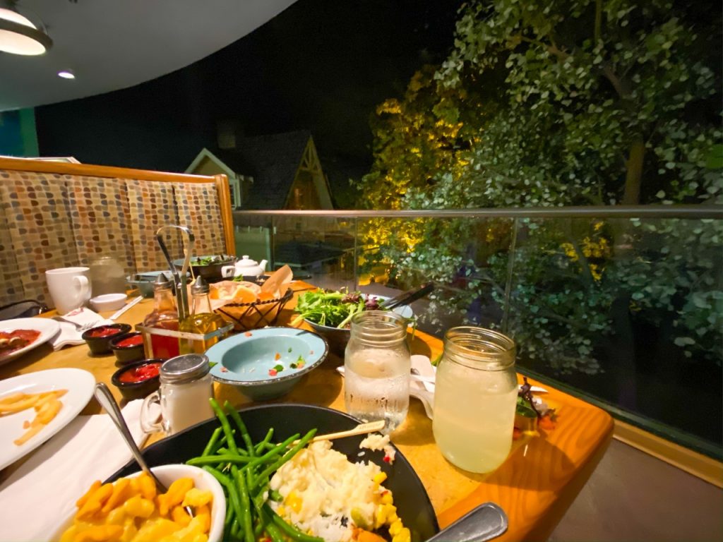 A photo of plates of food at a restaurant that spins around, giving toddlers an interactive view of the area-- it is perfect dining for Disney with toddlers. 
