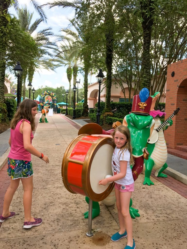 A photo of young children enjoying the colorful Alligator statues at Port Orleans Resort French Quarter, which is one of the best resorts to stay at when doing Disney with toddlers 