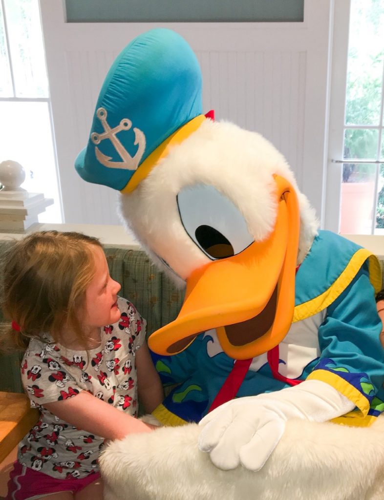 A photo of little girl sitting and chatting with Donald Duck: this is what Disney with toddlers is about.