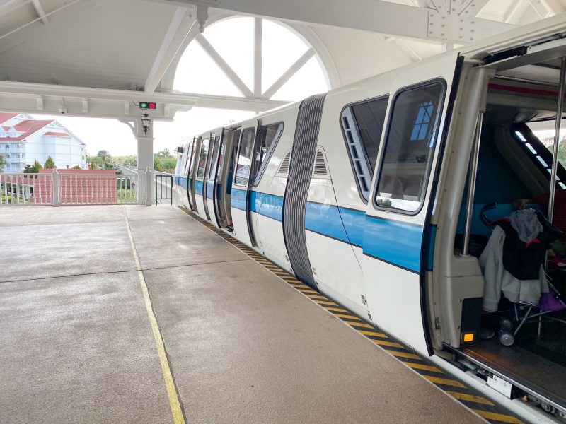 A photo of the monorail in a station, with doors open showing an unfolded stroller. The monorail makes traveling to Disney with toddlers easier, especially with strollers.