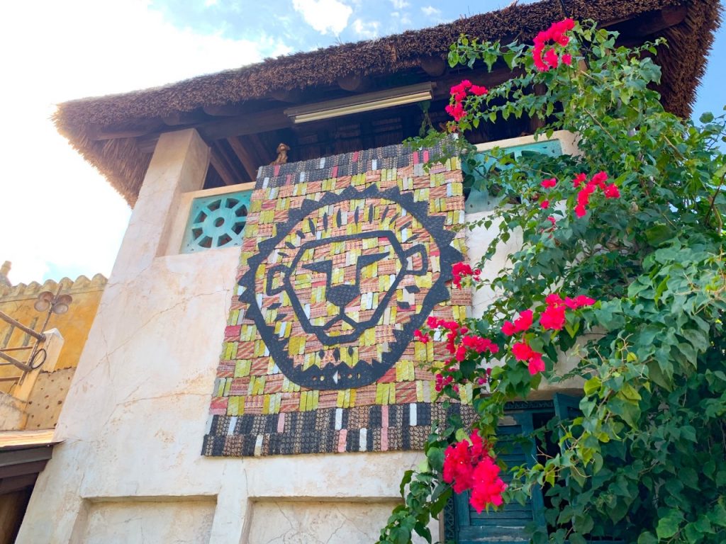 woven flag with image of a lion on it against a building 