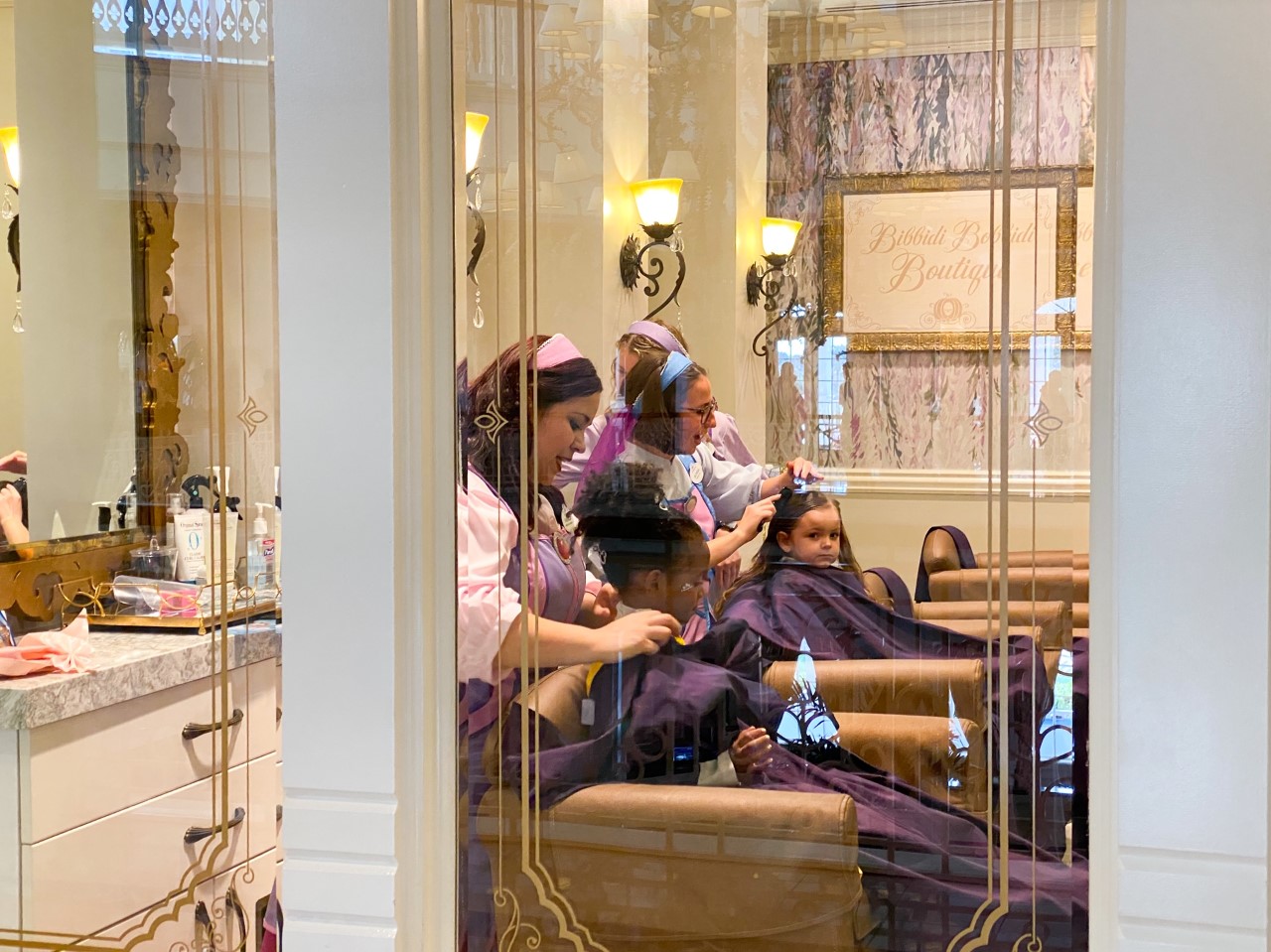 photo of children having their hair dressed at Bibbidi Bobbidi boutique by Fairy Godmothers in training; tipping at Disney